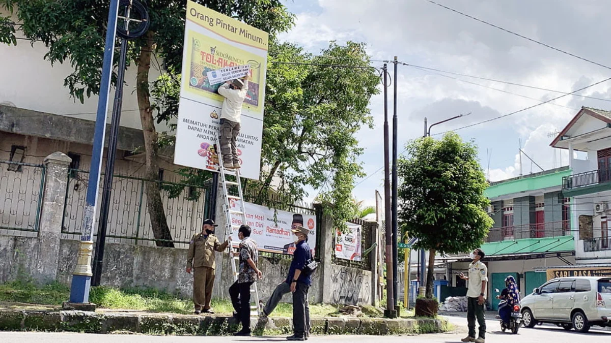 Satpol PP Pasang Stiker di Reklame Tak Berizin