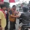 Ketua Kwartir Cabang Pramuka Kota Tasikmalaya H Muhammad Yusuf membagikan takjil kepada pegendara.