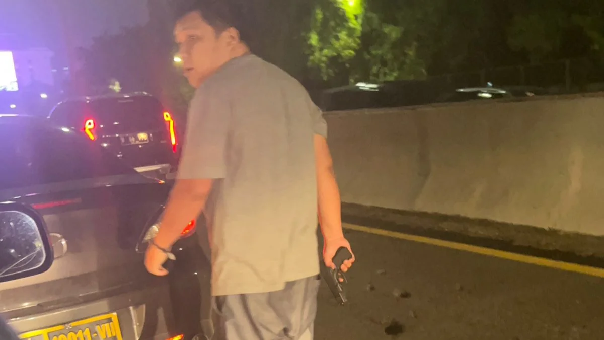 Video viral seorang pria menenteng pistol turun dari mobil polisi dan menganiaya sopir taksi online