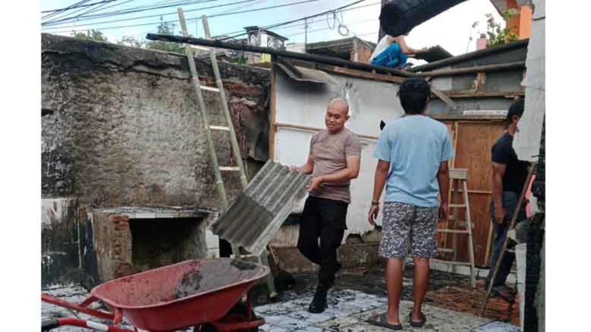 Polisi membantu warga membersihkan puing bangunan yang terbakar akibat obat nyamuk bakar.